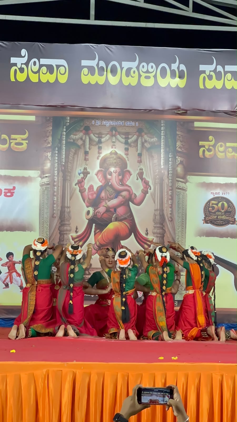 Bharatanatyam dancers kneeling in a circular stage formation