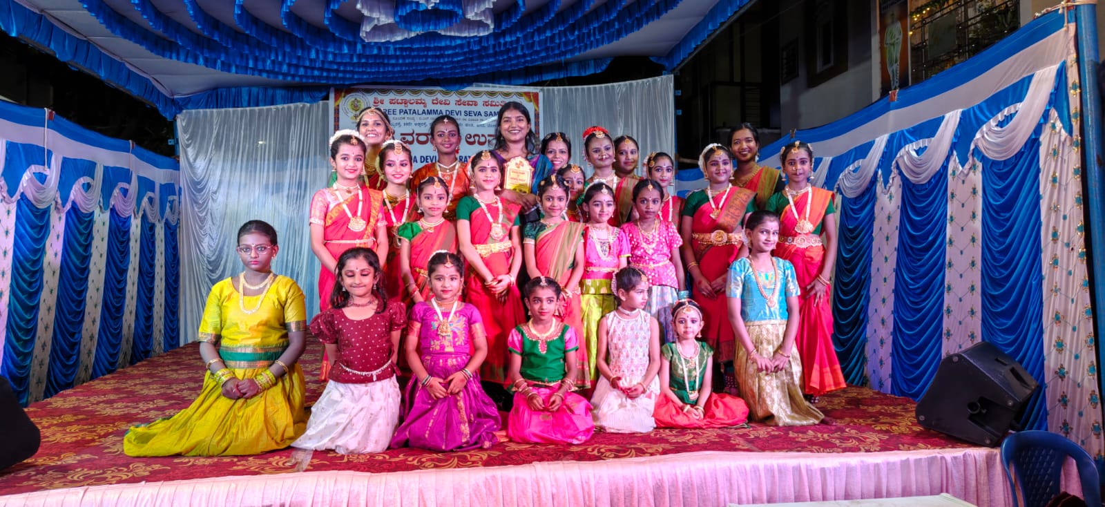Students and teachers gathered on a decorated stage